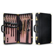 Two leather-bound cases from the Temptasia Safe Word Bondage Kit by Blush are shown. The left case is open, revealing various BDSM accessories including cuffs, collars, chains, paddles, and a gag—perfect for both beginners and intermediate players. The right case is closed, showcasing its exterior. Both have gold accents, handles, and lock mechanisms.