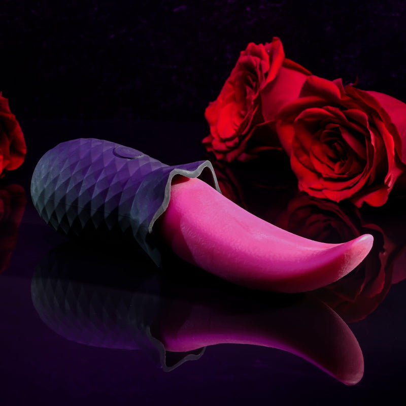 The Tongue Teaser Flickering Realistic Red Tongue Vibrator by Evolved Novelties, featuring a textured black handle, rests on a reflective black surface. In the background, two red roses add a romantic ambiance. The dark lighting highlights the toy and roses, accentuating its promise of realistic oral sensations while being waterproof and submersible.