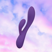 Purple UltraSilk satin-smooth silicone G-spot rabbit vibrator with curved shaft and flexible teaser against a cloudy sky.