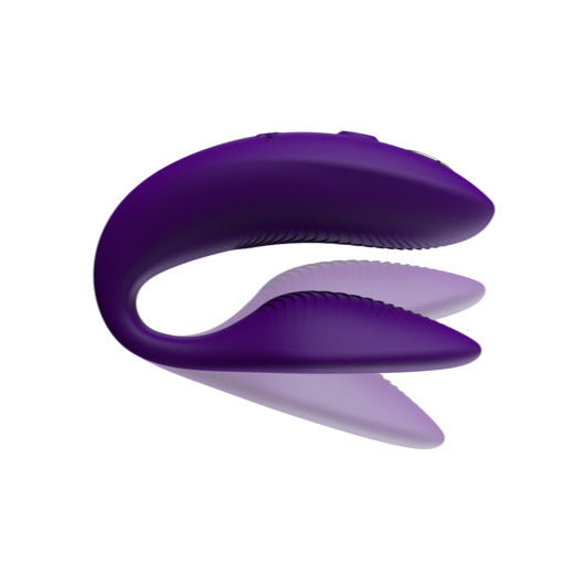 The We-Vibe Sync 2 Wearable Couples Vibrator in purple is a U-shaped silicone vibrator with ribbed inner edges, remote and app controlled, shown against a white background.