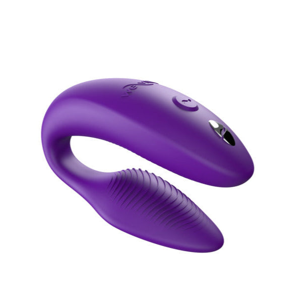 The We-Vibe Sync 2 is a purple, U-shaped wearable couples vibrator with smooth buttons and a textured arm, remote and app-controlled, shown on a plain white background.