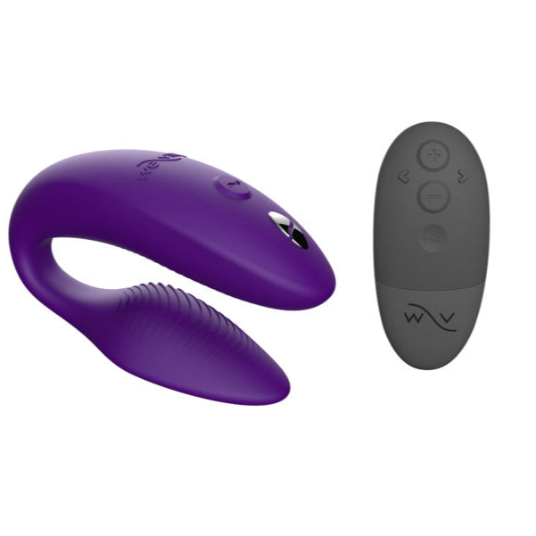 The We-Vibe Sync 2 Purple, a curved wearable couples vibrator with textured ridges, is shown alongside a black wireless remote control with multiple buttons. This device is remote and app controlled for versatile use.