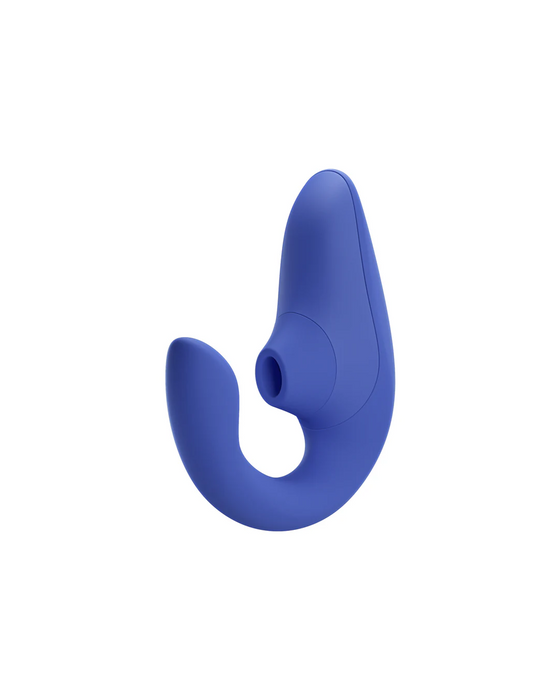 A blue, ergonomically shaped personal massager with a curved design and G-spot vibrations on one side. The Womanizer Blend Pleasure Air Clitoral & G-Spot Rabbit - Blue by Womanizer has a smooth surface and is designed for comfortable handling and targeted use, offering dual stimulation for enhanced pleasure.