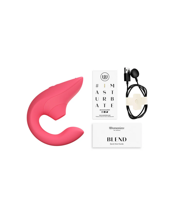 A pink, curved Womanizer Blend Pleasure Air Clitoral & G-Spot Rabbit - Rose vibrator is displayed alongside a quick start guide, a charging cable with USB, and a booklet labeled "IMASTURBATE." The items are arranged neatly against a white background.