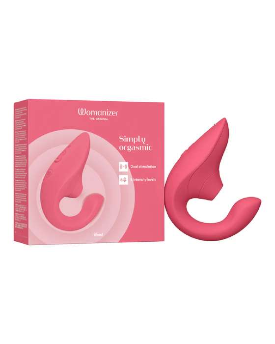 A pink sexual wellness device is shown alongside its packaging. The box, primarily pink, displays the product image, reads "Womanizer Blend Pleasure Air Clitoral & G-Spot Rabbit - Rose," and highlights features like "dual stimulation" and "6 intensity levels." The rabbit vibrator has a curved, ergonomic design.