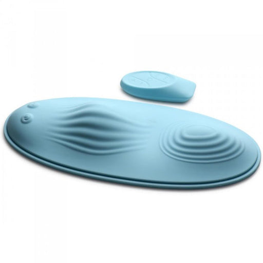 The Wave Slider Remote Control Vibrating Humping Pad, in light blue with an oval shape and textured wavy ridges, comes with a matching small grip pad, both displayed on a white background.