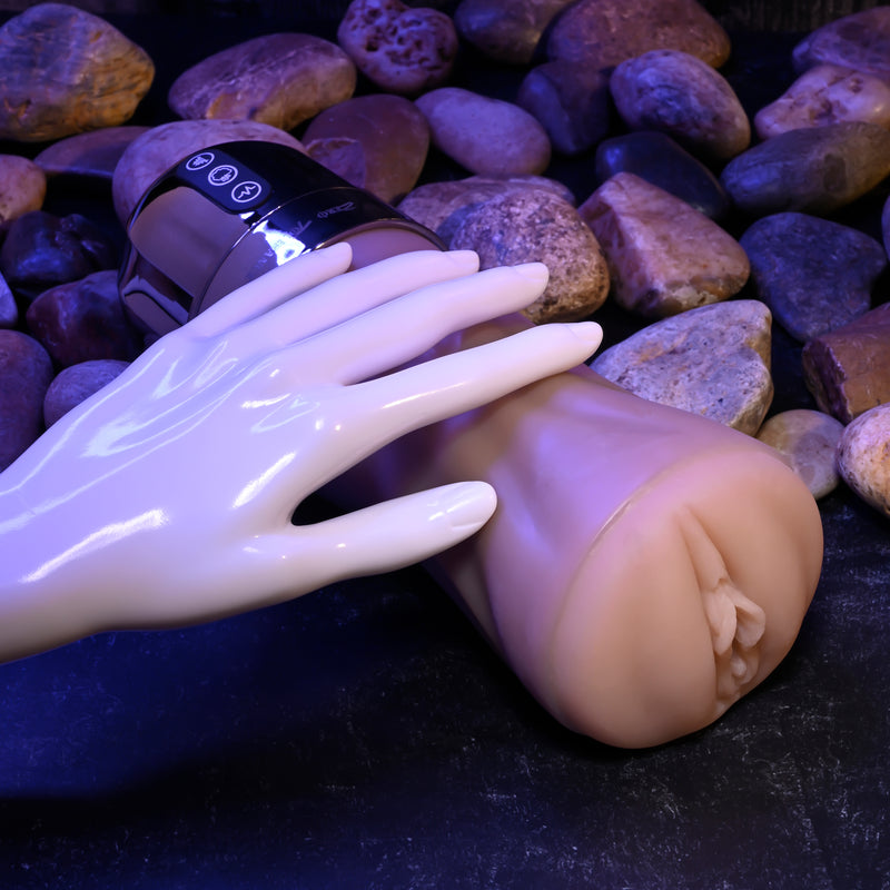 A hand touching the Tight Lipped Vibrating Vanilla Stroker with Suction + Free Movie Download.