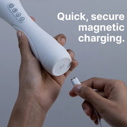 Hands connecting a white magnetic charging cable to the base of a white silicone vibrator.