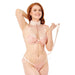 A smiling woman with long red hair models pink lace lingerie and the Peaches 'n Cream Fur Collar and Leash, confidently posing against a plain white background while holding the matching leash.