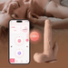 A woman smiles on a bed beside a smartphone running a control app and the Colter Thrusting Large 8.5" Realistic App Controlled Dildo with Clit Licker, hinting at an interactive Bluetooth-enabled vibrator experience.