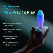 White silicone butt plug with a glowing blue and purple LED tip, held by a hand.