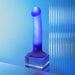 The Glow Blue LED 7 Inch Light Up Silicone Dildo, featuring a blue translucent design, stands upright on a clear square base against a blue background with reflective, glass-like panels.