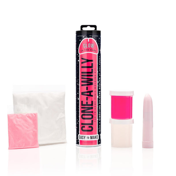The Clone A Willy Vibrating Silicone Penis Casting Kit - Glow In the Dark Pink is shown with a cylindrical package, pink and white powder bags, two plastic containers, and a vibrator—perfect for making your own glow in the dark dildo.