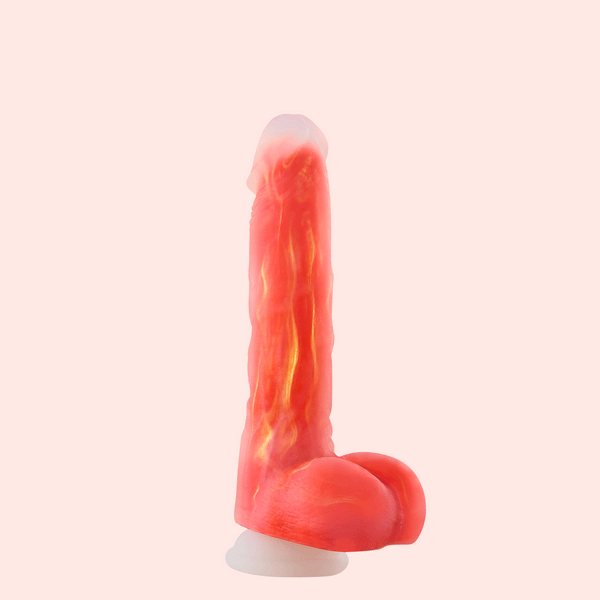 The Noctura Thrusting Silicone Dildo with App Control, in pink and red silicone with realistic vein-like detailing and a suction base, stands upright against a light pink background.