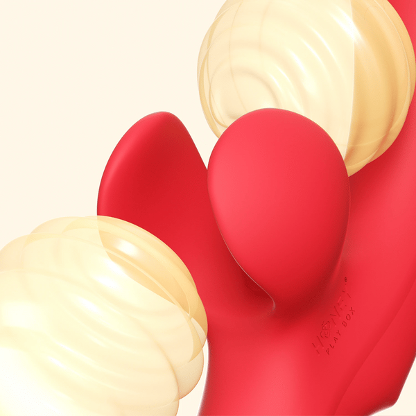 Close-up of the Fortexa Kinky Finger Rabbit Vibrator with App Control—red silicone, two rounded ends, translucent spiral-textured yellow caps, and embossed “Honey Play Box” text. Set against an off-white background.