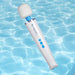 The Magic Wand Waterproof Rechargeable Cordless Vibrator, featuring blue buttons, floats over clear, rippling pool water.
