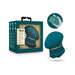 The Riana Circular Clitoral Rubbing Vibrator, made from body-safe dark teal silicone with gold accents, is shown beside its packaging. An illustration highlights its ergonomic shape and size while held in a hand.