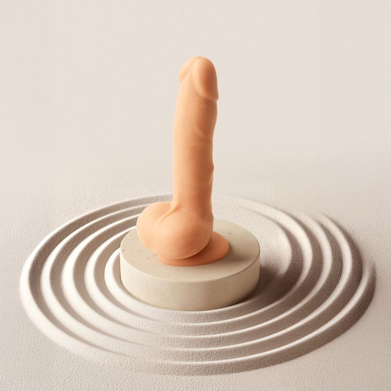 Realistic vanilla dildo with a lifelike glans and silky-smooth texture, standing on a circular pedestal.