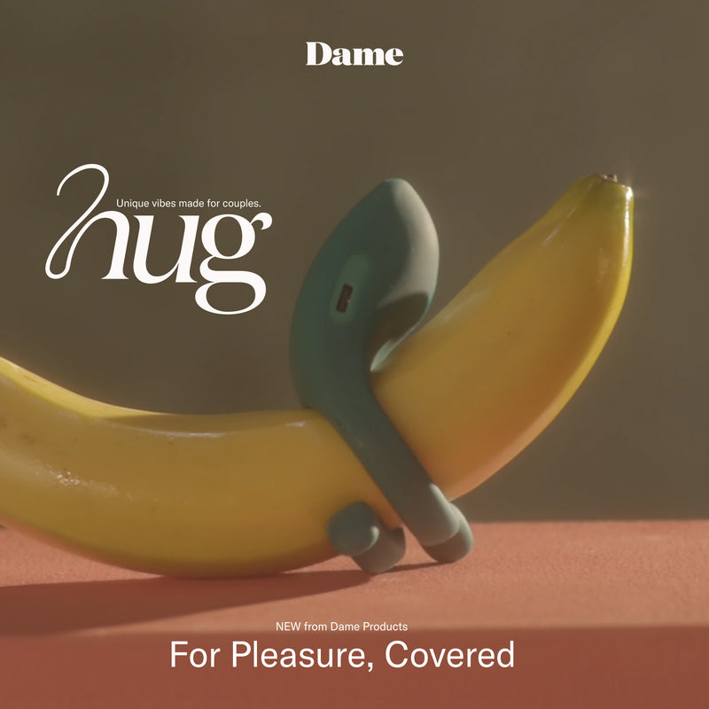 A green silicone Dame Hug Adjustable Vibrating Cock Ring for Couples, designed to wrap around a banana, sits on an orange surface. The text reads "hug," "Dame," and "For Pleasure, Covered. NEW adjustable cock ring from Dame Products.